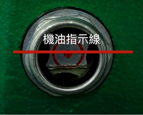 Close-up of an air compressor oil sight glass showing a mid-level marking to indicate that the oil level should stay above the line.